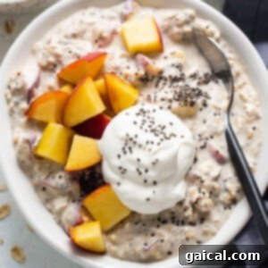 A bowl of oatmeal with peaches and whipped cream.