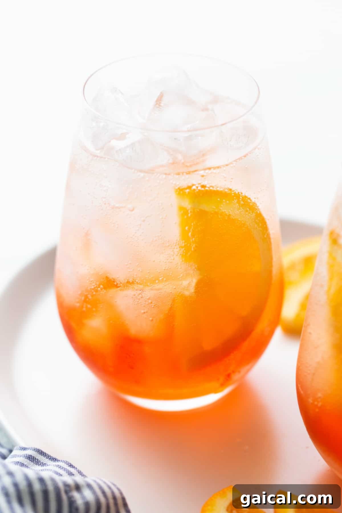 The refreshing allure of a perfectly garnished Aperol Spritz. A perfectly prepared Aperol Spritz in a glass, garnished with a vibrant orange slice, ready for a refreshing sip.