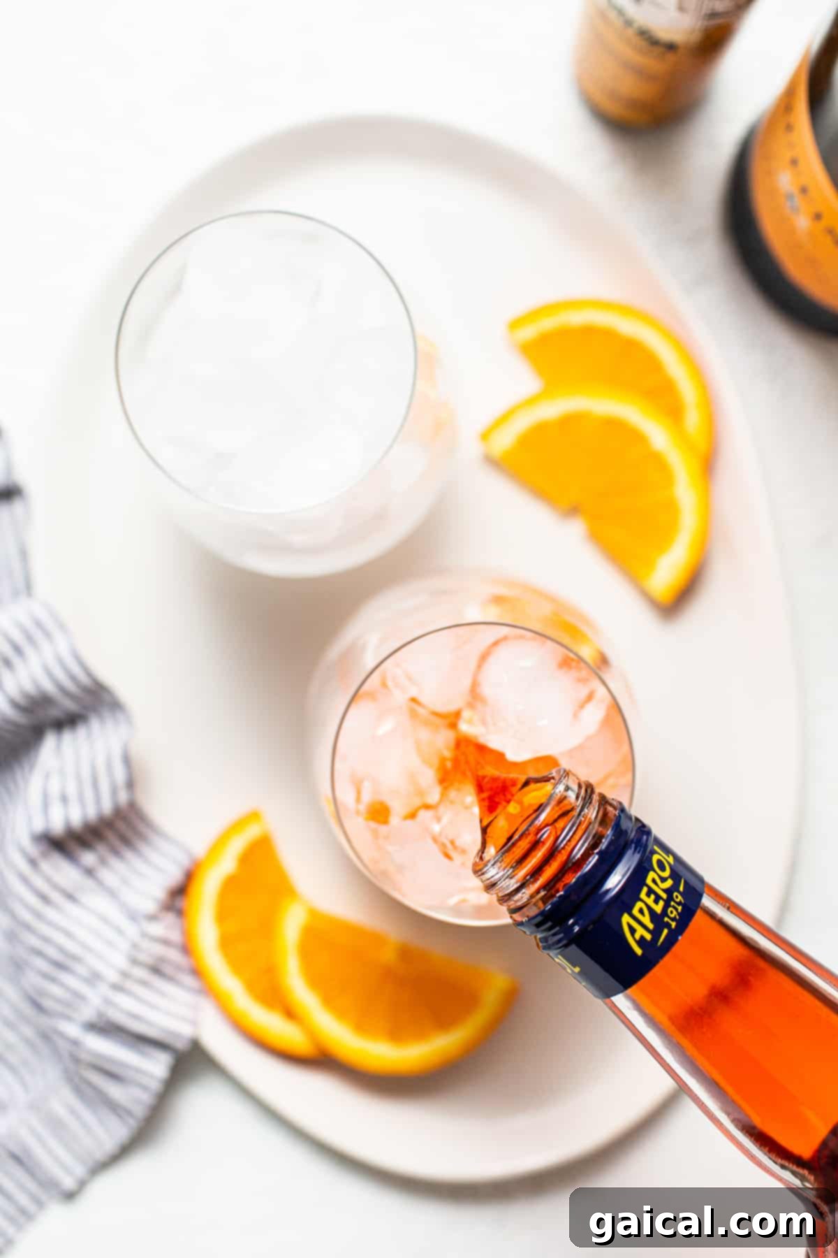 The heart of the Aperol Spritz: its signature vibrant orange liqueur. Aperol being carefully poured into a glass, showcasing its vibrant orange hue.