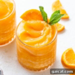 Iconic Aperol Spritz 2 Aperol spritz slushy in glass, garnished with an orange slice.