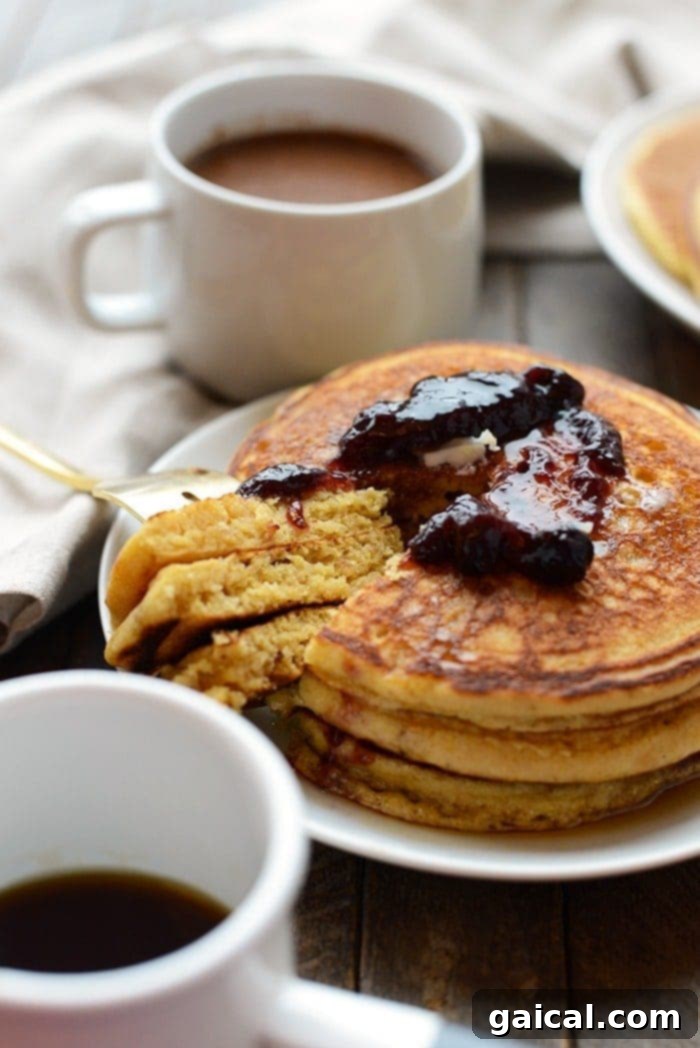 An overhead shot of several whole wheat cornmeal pancakes stacked neatly, ready to be served.