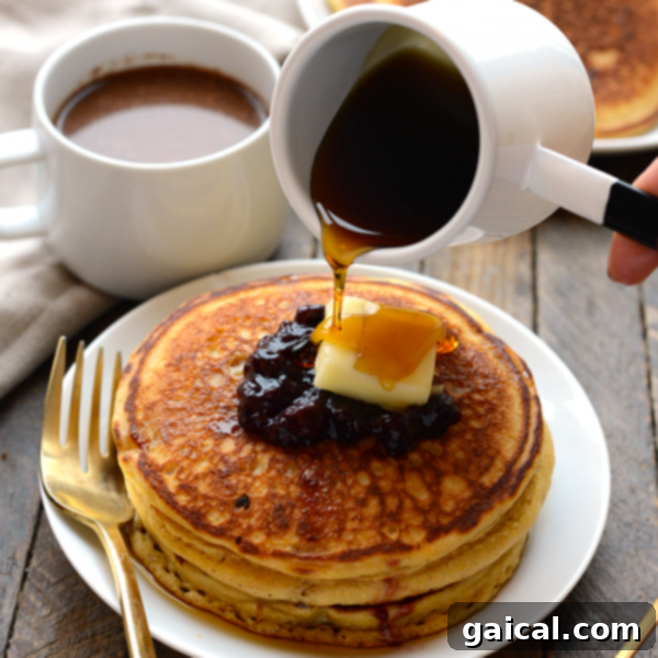A beautifully presented stack of Whole Wheat Cornmeal Pancakes on a plate, ready to be enjoyed.