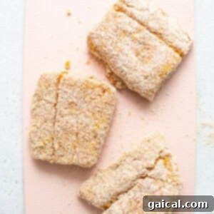 Three pieces of cookies on a pink cutting board.