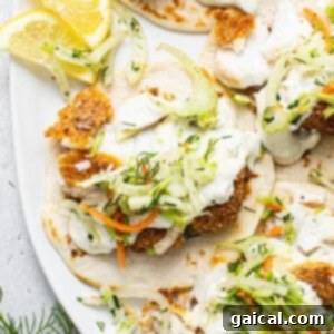 Fish tacos with slaw and lemon wedges.