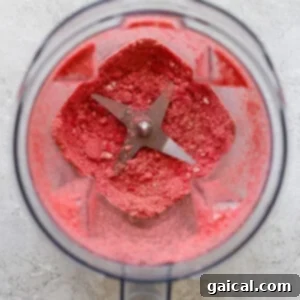 Protein-Packed Strawberry Shortcake Ice Cream Bars 12 A food processor filled with a pink, finely ground substance, suggesting a crumbly mixture.