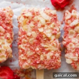 Protein-Packed Strawberry Shortcake Ice Cream Bars 9 Close-up of three strawberry and almond popsicles, showcasing their texture and vibrant color.