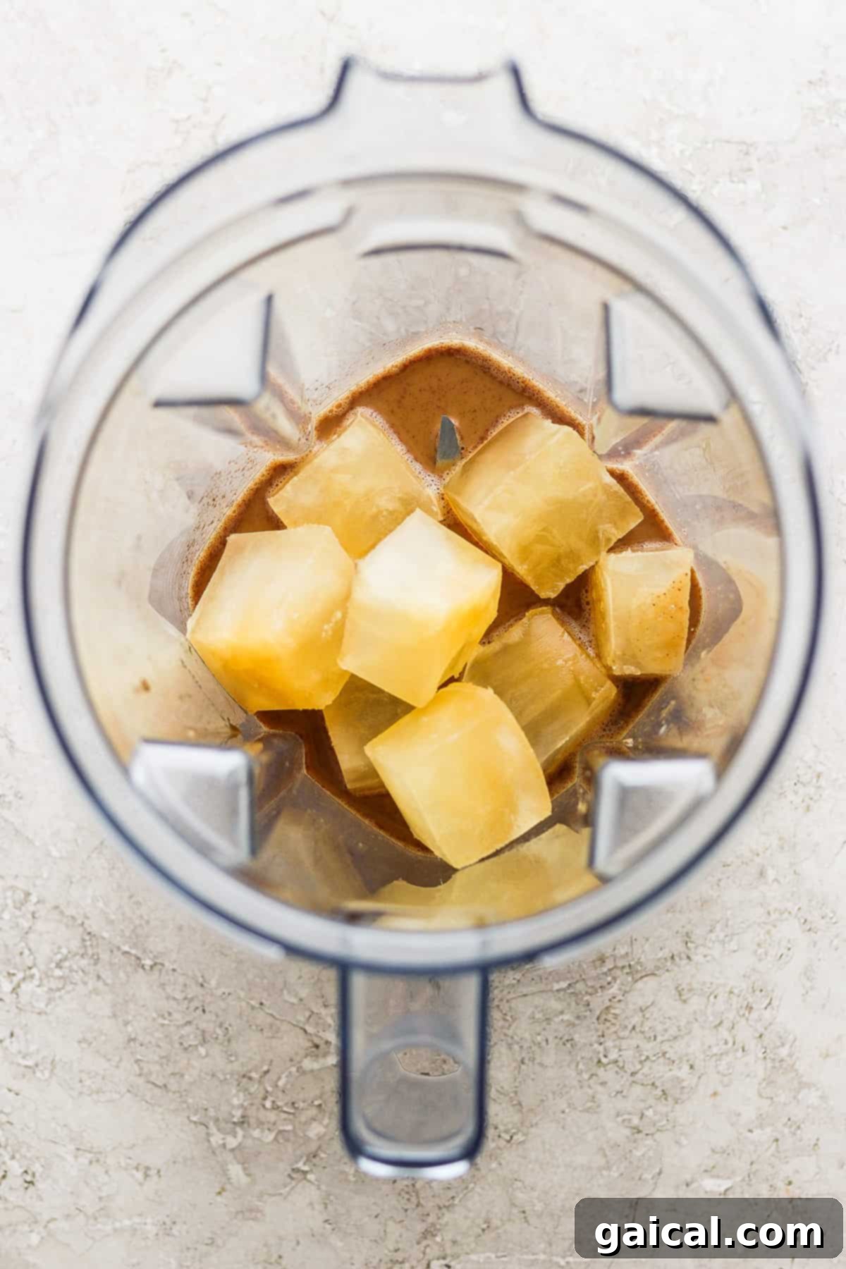 Maple Kissed Apple Crisp Oatmilk Blend 5 A blender with chunks of fresh pineapple, illustrating its blending power.