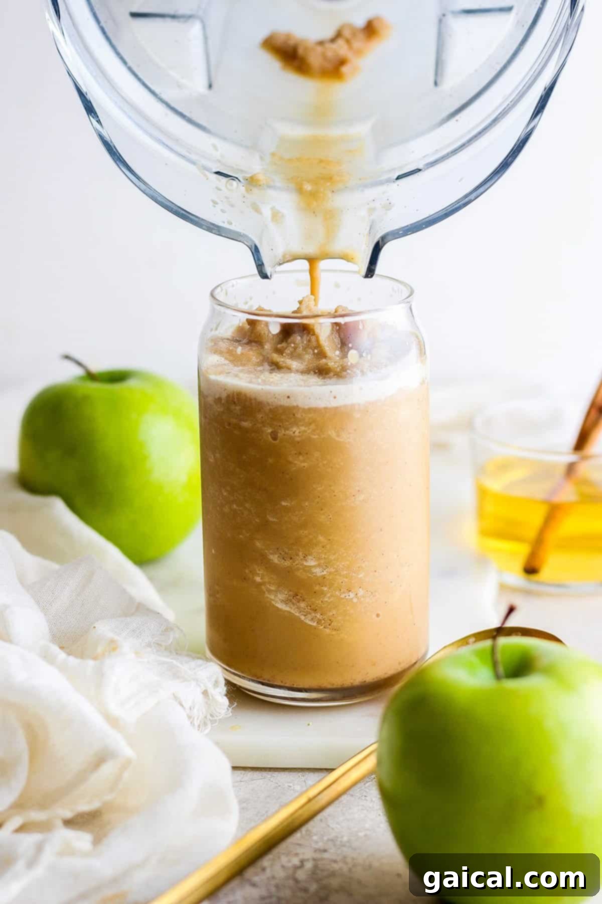 Maple Kissed Apple Crisp Oatmilk Blend 6 Fresh apple juice being poured into a clear glass, inviting and refreshing.