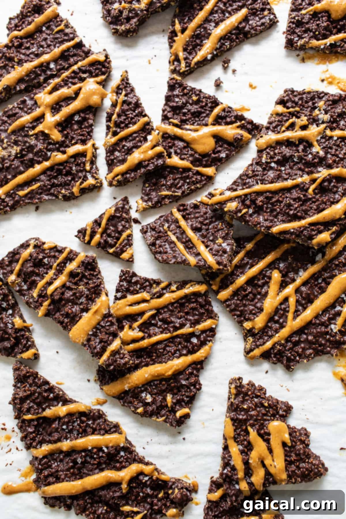 A beautiful pile of chocolate quinoa crisps, drizzled with creamy peanut butter and sprinkled with sea salt, ready to be enjoyed.