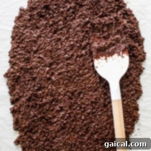 The chocolate quinoa mixture spread on a sheet pan, with peanut butter drizzled on top and a sprinkle of flaky sea salt.