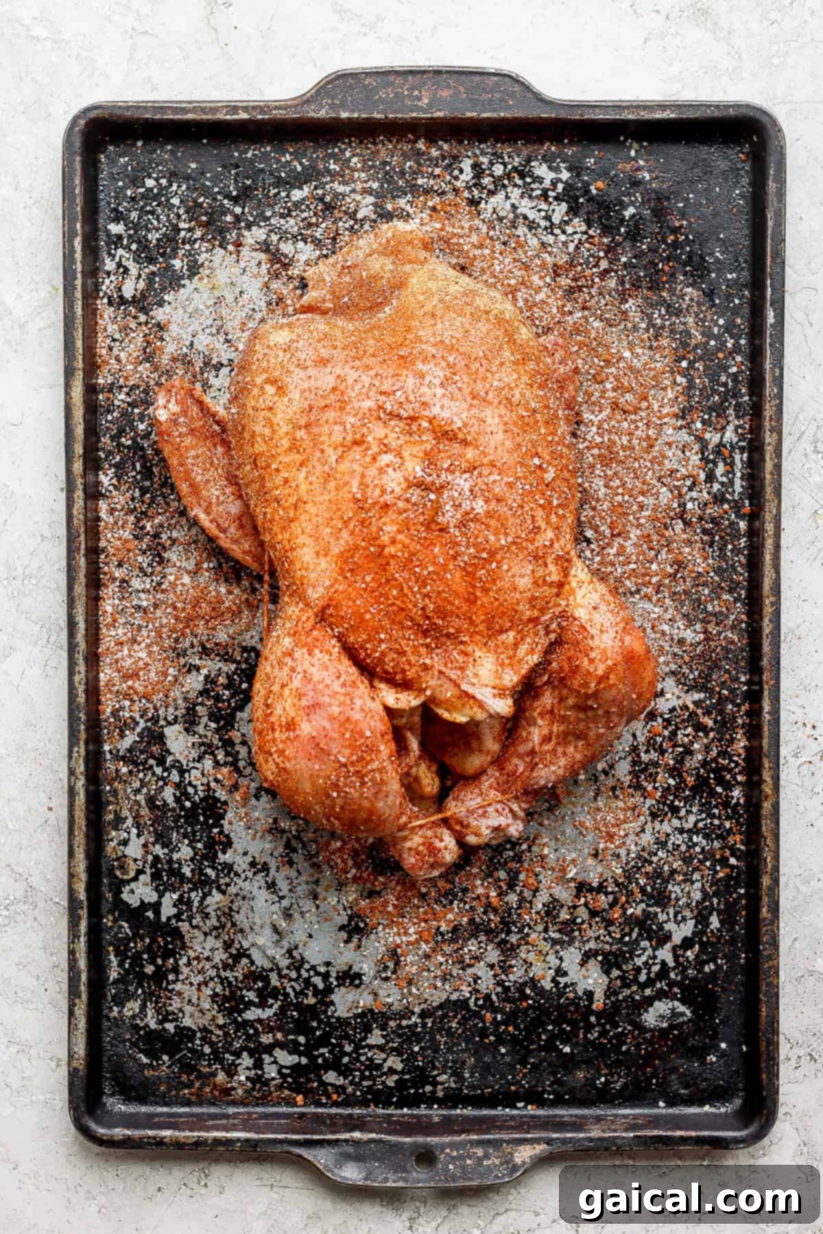 One-Pot Spanish Roast Chicken Dinner 5 A perfectly roasted whole chicken on a baking sheet, golden and crispy.