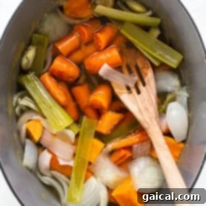 a pot filled with carrots, celery and onions.