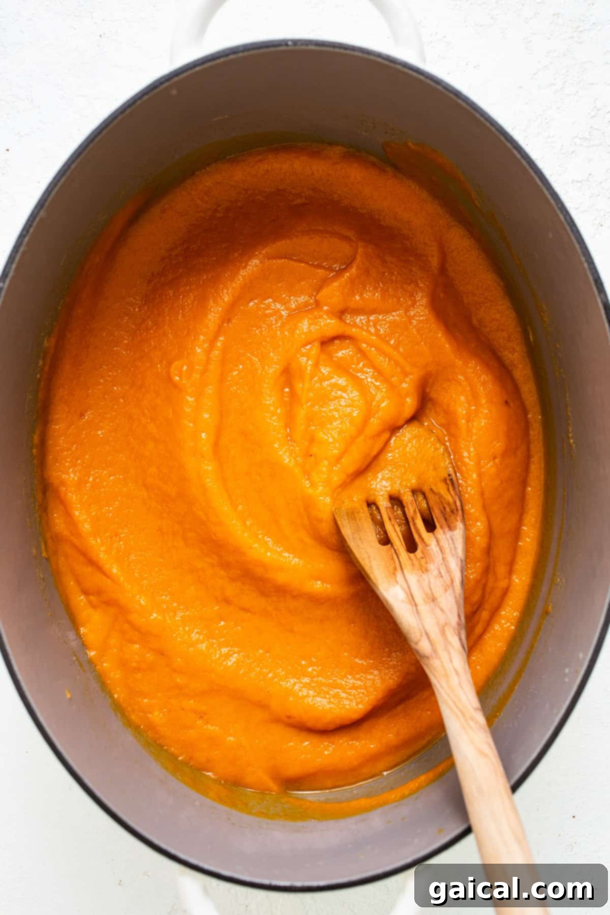 Stealthy One-Pan Spaghettios 4 a wooden spoon in a pot of orange sauce.