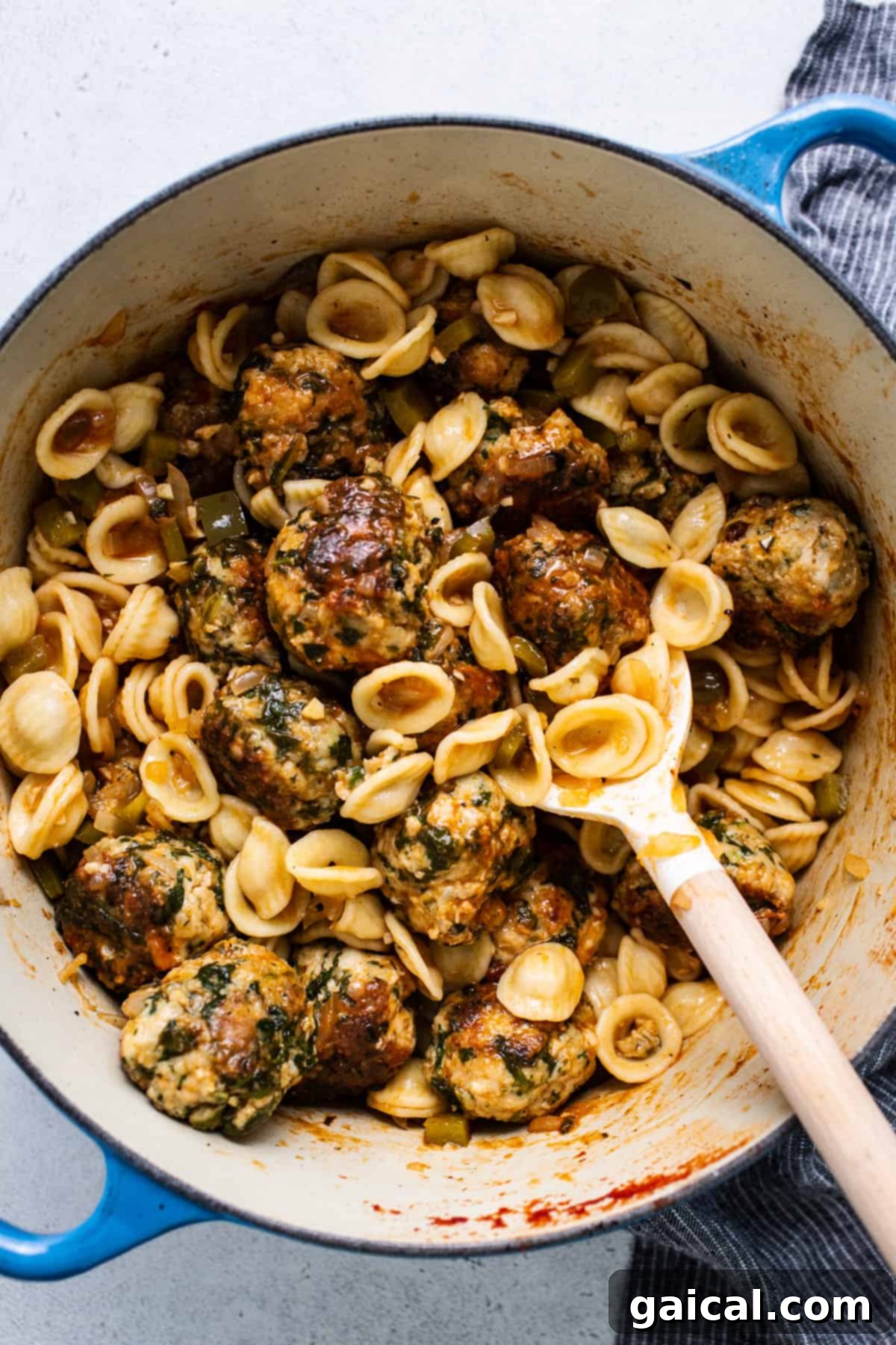 A generous pot filled with creamy Tuscan pasta and chicken meatballs, ready for serving.
