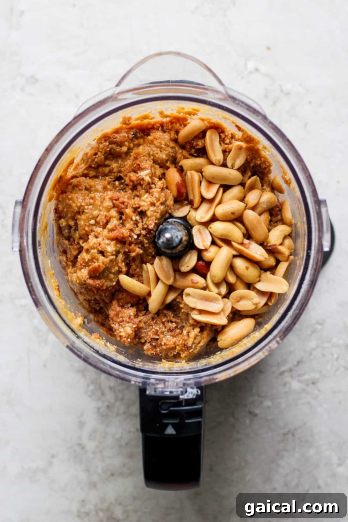 Autumn's Wholesome Kitchen Collective 5 A food processor actively blending peanuts and other key ingredients for a rich, textured energy ball mixture.