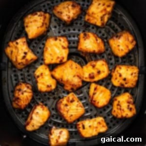 Golden Honey Chili Air Fryer Salmon Bites 10 A close-up view of perfectly cooked and flaky air fryer salmon bites, showcasing their tender interior and delicious texture.