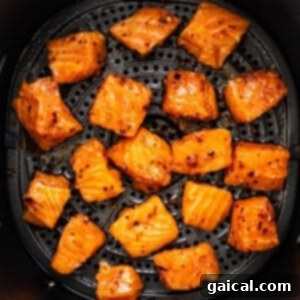 Golden Honey Chili Air Fryer Salmon Bites 9 Air fryer basket filled with honey chili crunch salmon bites, cooking to a golden-brown and crispy perfection.