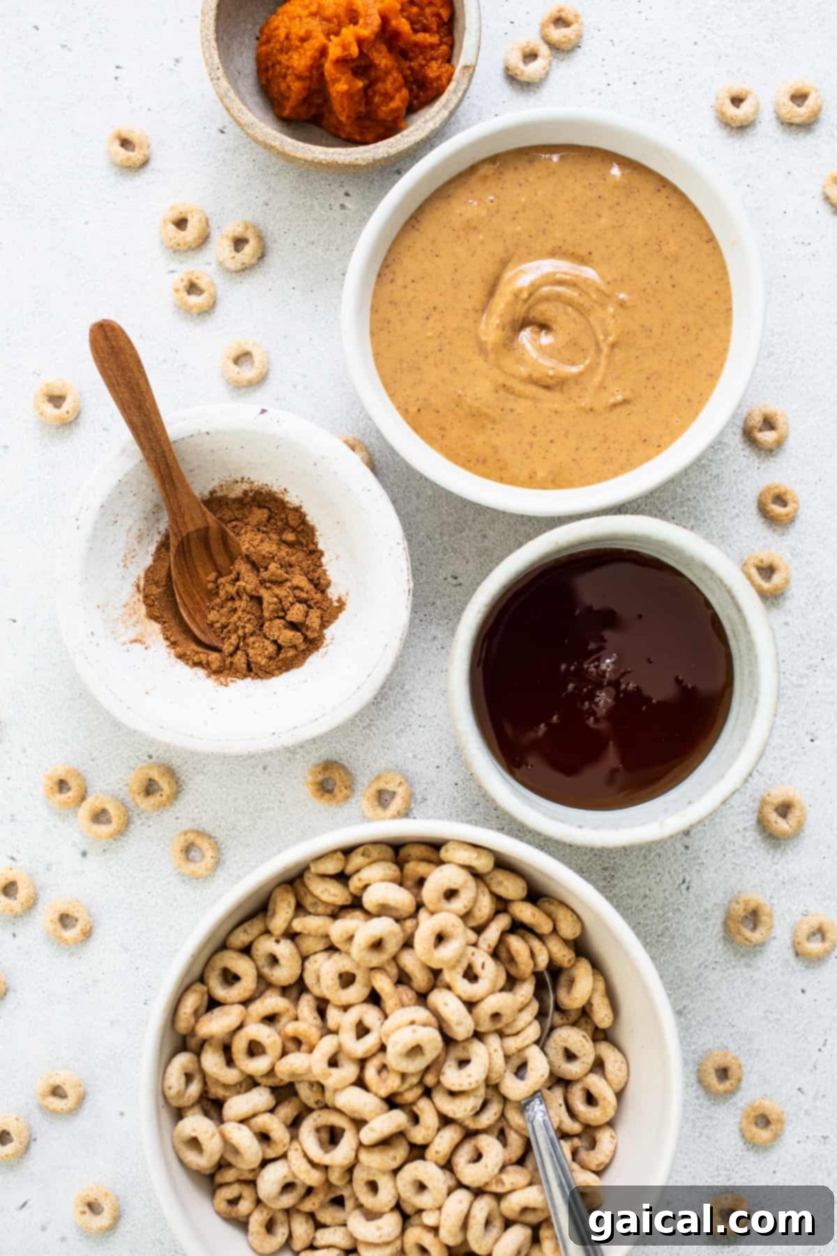 Pumpkin PB Cereal Bars 3 A bowl of cereal, a bowl of peanut butter, a bowl of oatmeal, and a bowl of granola.