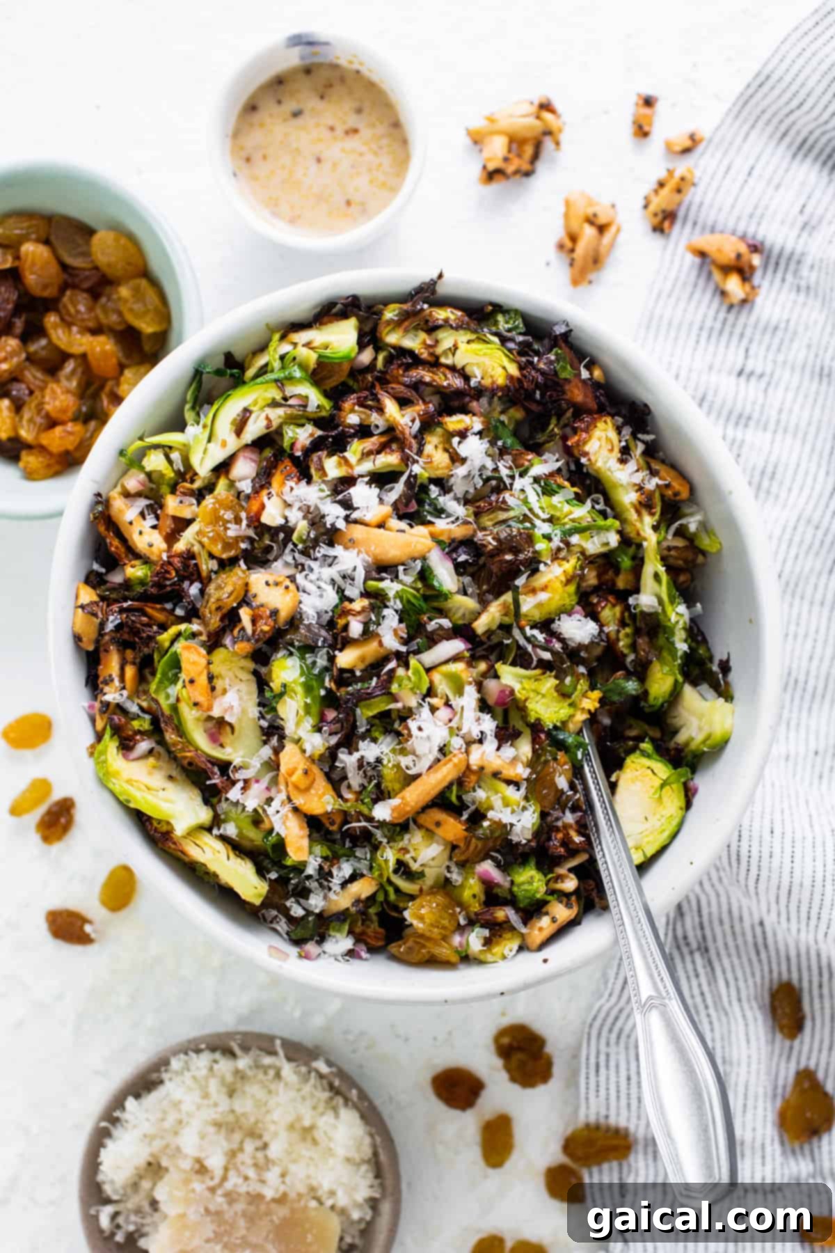 A bowl of brussels sprouts salad with nuts and raisins.