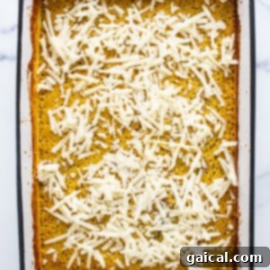 Hearty Butternut Chicken Sausage Quinoa Bake 11 A white baking dish with a layer of cheese on top, ready to be broiled.