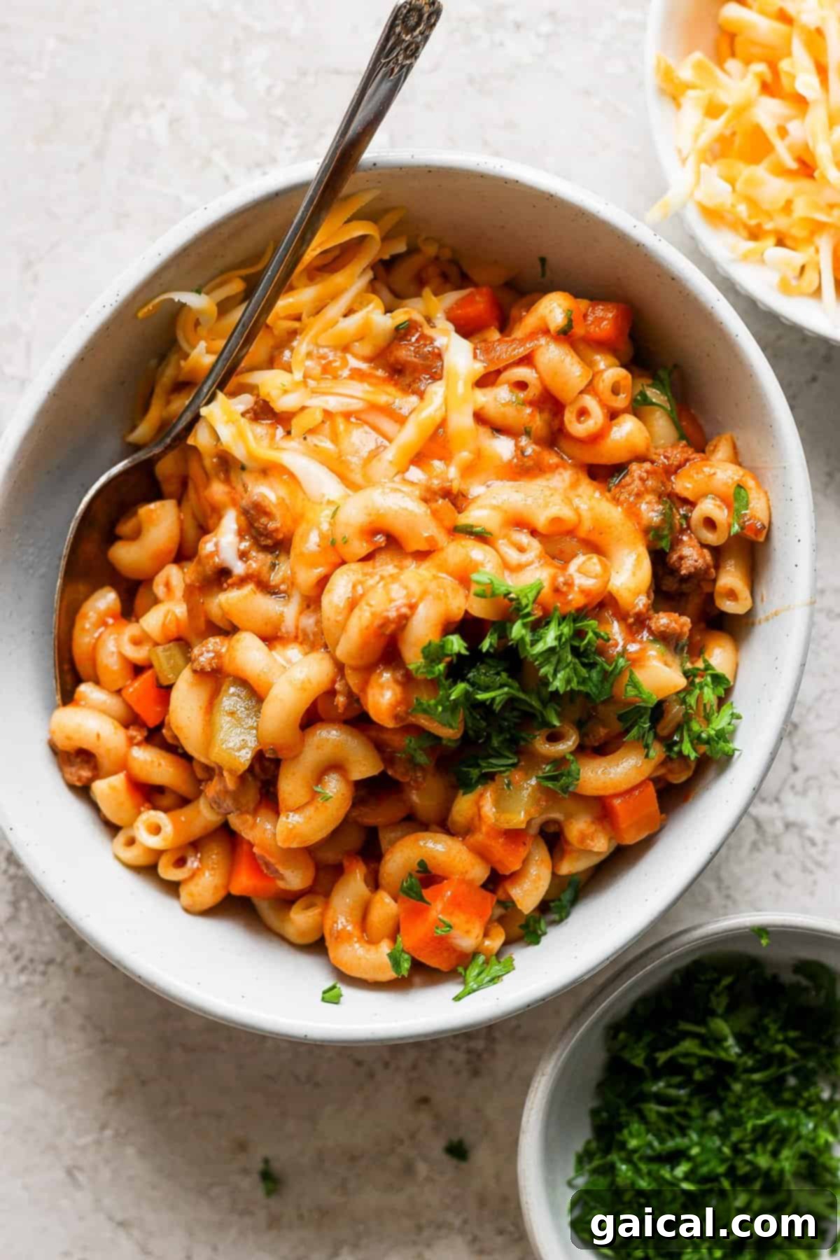 Skillet Ground Beef Pasta 5 A comforting bowl of macaroni and cheese with ground beef, carrots, and a garnish of fresh parsley.