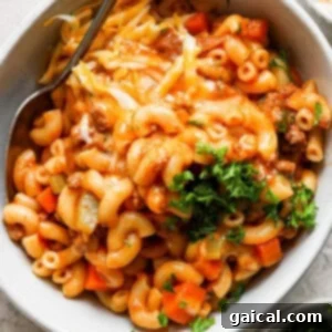 A serving of macaroni and cheese with ground meat and vegetables in a bowl.