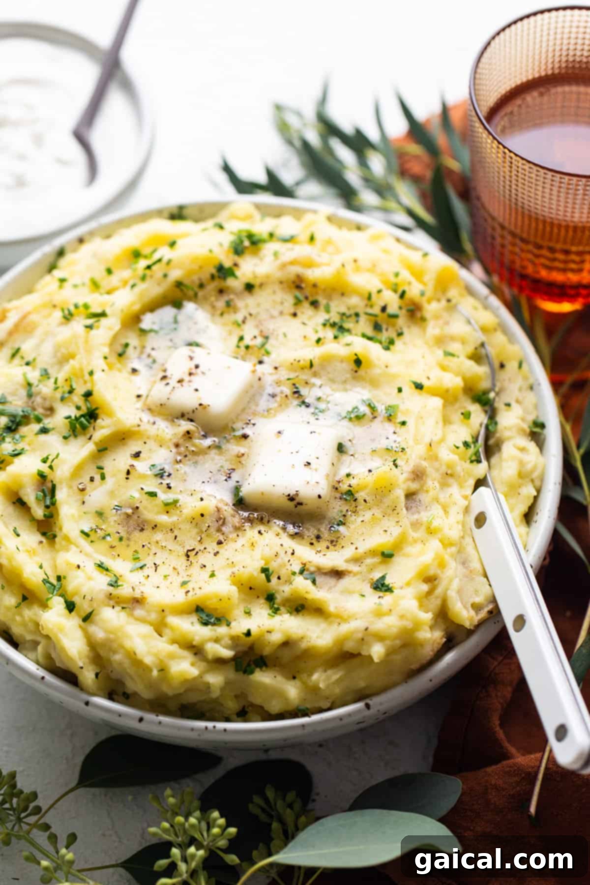 Nourishing November Fit Foodie Culinary Adventures 7 A generous serving of creamy mashed potatoes, garnished with fresh herbs and a swirl of sour cream, ready to be enjoyed.