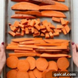 Sweet potatoes cut into a variety of shapes on a baking sheet.