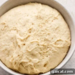 Nutty Brown Butter Banana Bread Cinnamon Rolls 8 A bowl of dough proofing, covered with plastic wrap and a tea towel.