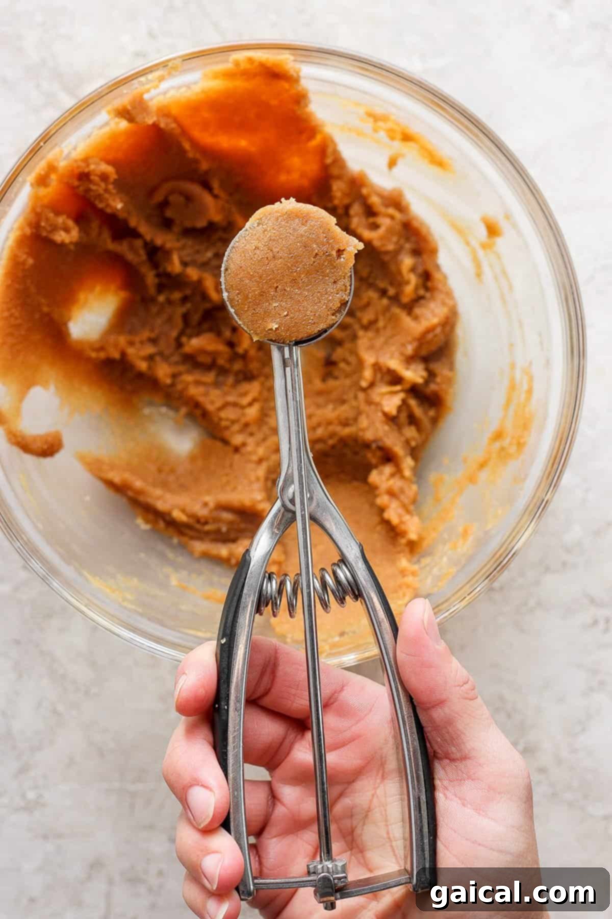 The Fit Foodie December Cooking Collective 2023 3 A person expertly using a hand mixer to combine the creamy peanut butter dough ingredients in a bowl.