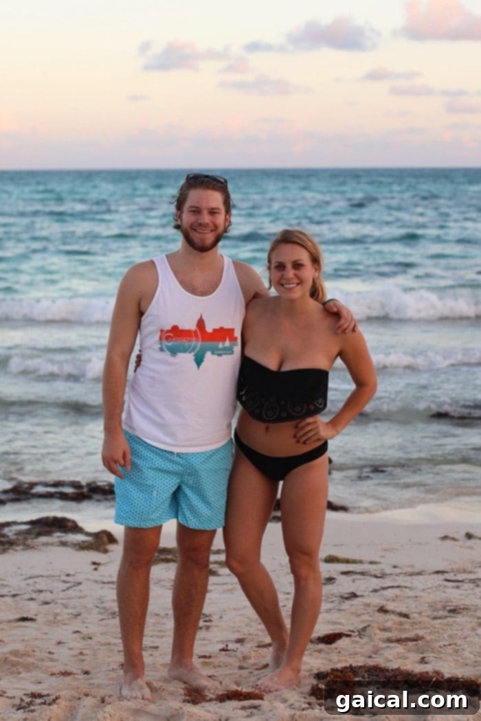 A couple posing happily on the beach, enjoying their vacation at Iberostar Grand Hotel Paraíso.