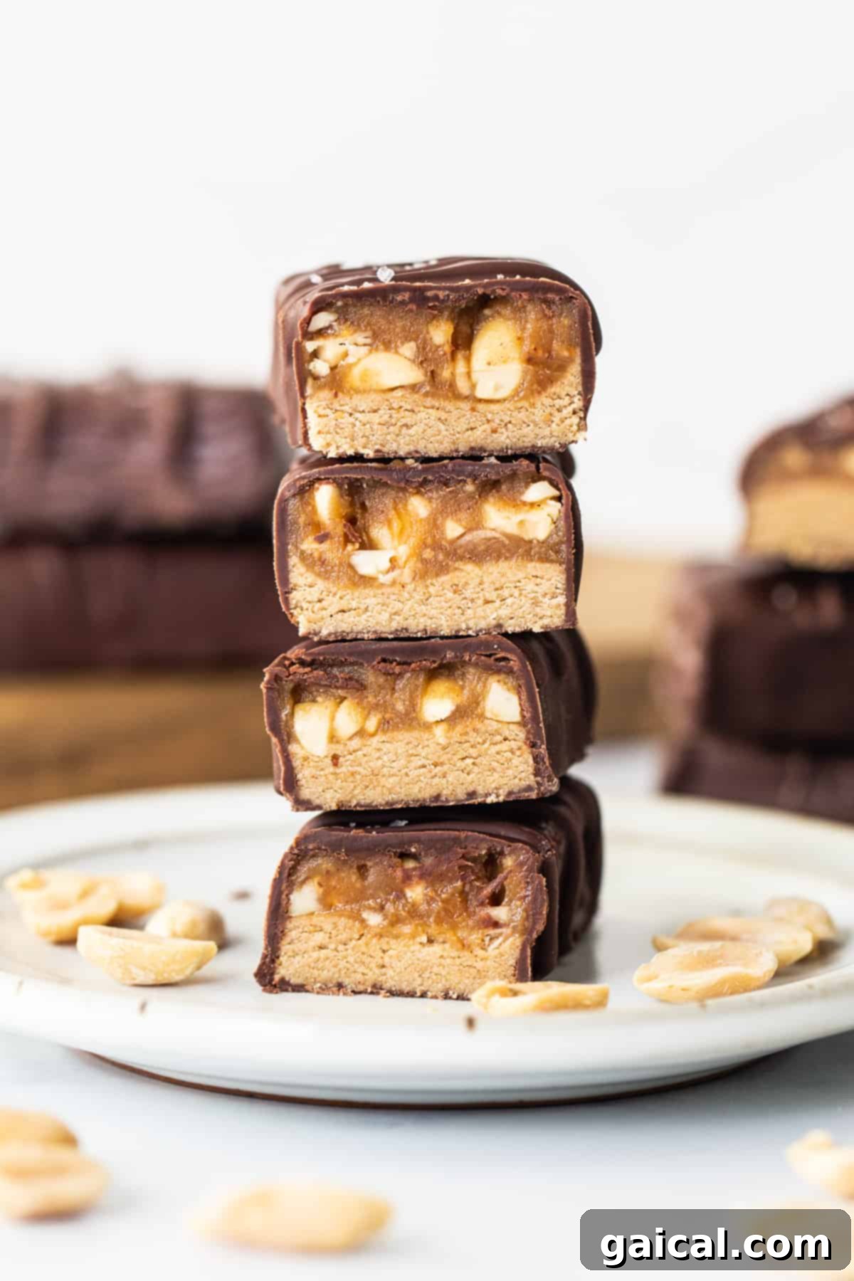 A stack of chocolate peanut butter protein bars on a plate, showcasing their inviting appearance and layered texture.