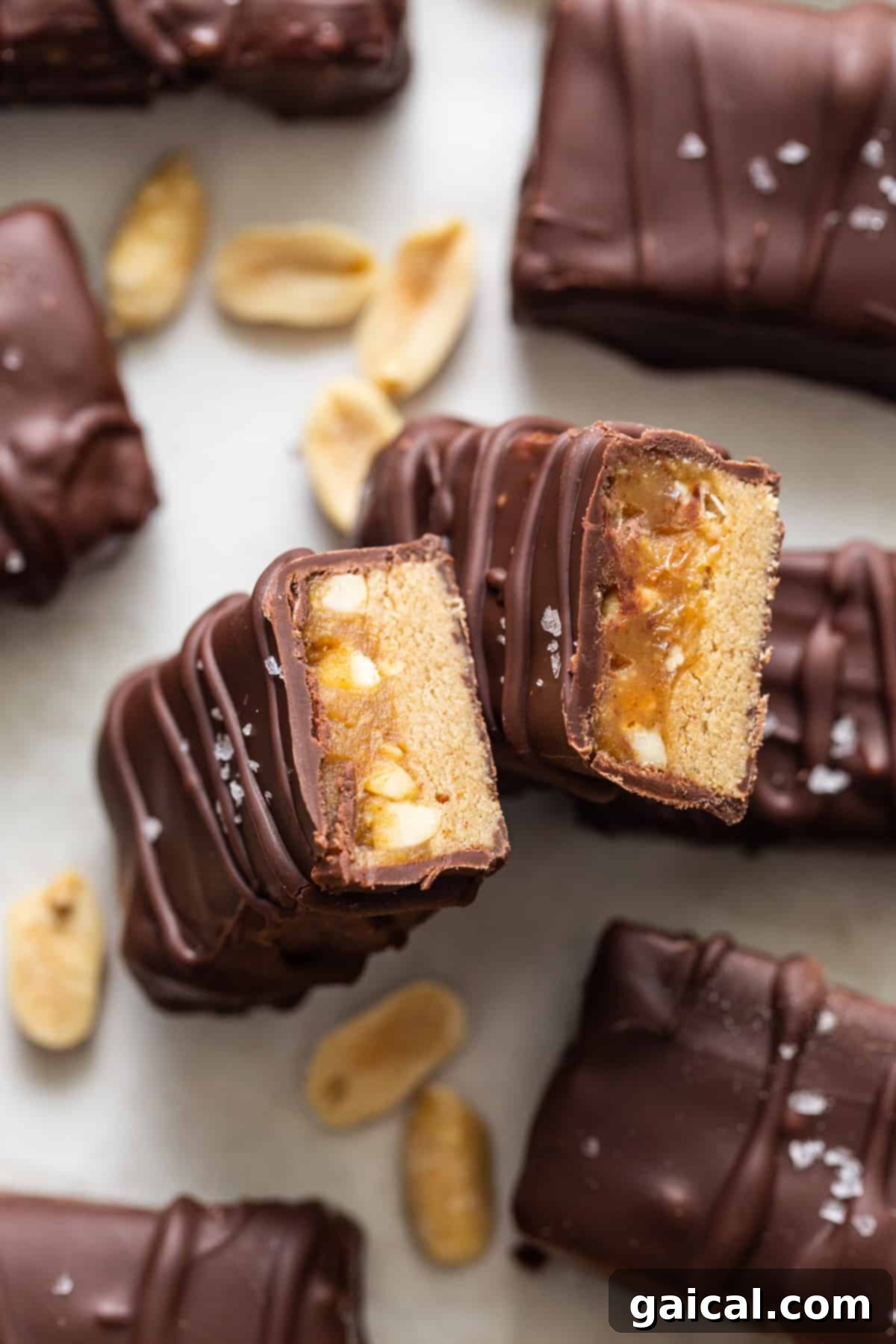Close-up view of chocolate peanut butter protein bars generously topped with chopped peanuts, beautifully arranged and ready to be enjoyed.