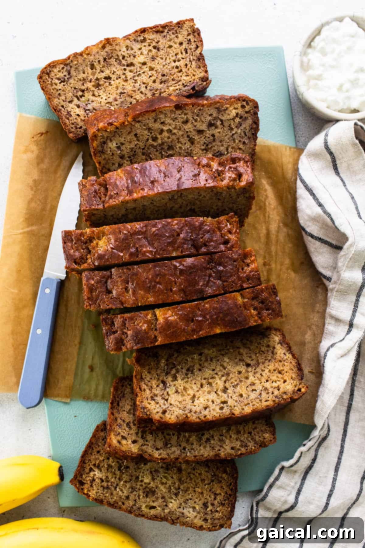 Protein-Boosted Banana Bread 15 Sliced banana bread on a cutting board with a knife, ready to be served.
