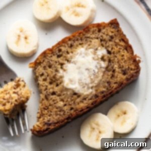 A slice of banana bread on a plate with a fork, representing the final dish.