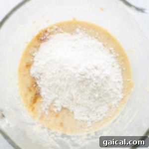 A glass bowl with flour and sugar in it.