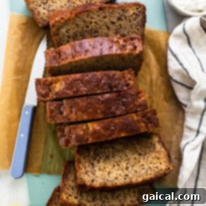 Sliced banana bread on a cutting board with a knife.