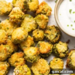 A plate of golden, crispy air fryer pickles with a side of creamy tangy dipping sauce, beautifully presented and ready to be enjoyed.