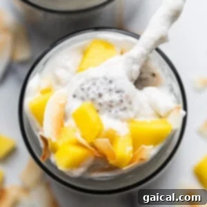A bowl of mango and coconut yogurt with a spoon, representing a fresh, healthy dessert similar to chia pudding.