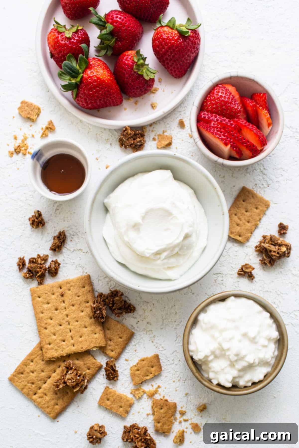 Creamy Protein Strawberry Cheesecake Jars 3 Strawberries, graham crackers and whipped cream on a white background.