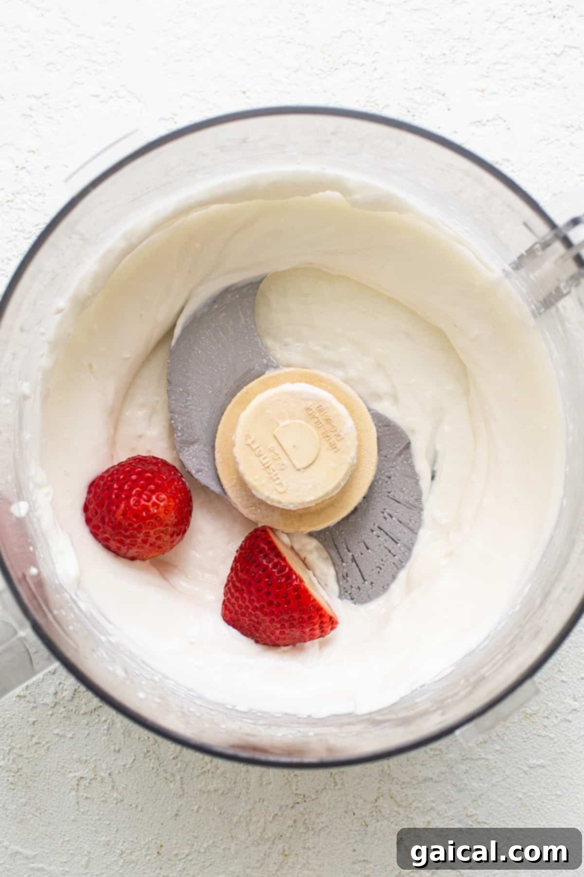 Creamy Protein Strawberry Cheesecake Jars 4 A food processor with whipped cream and strawberries.