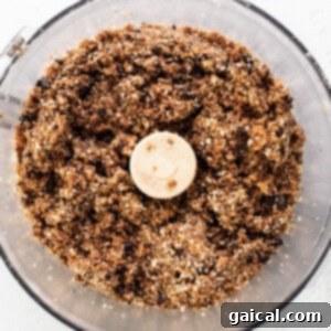 A food processor filled with granola and a banana.