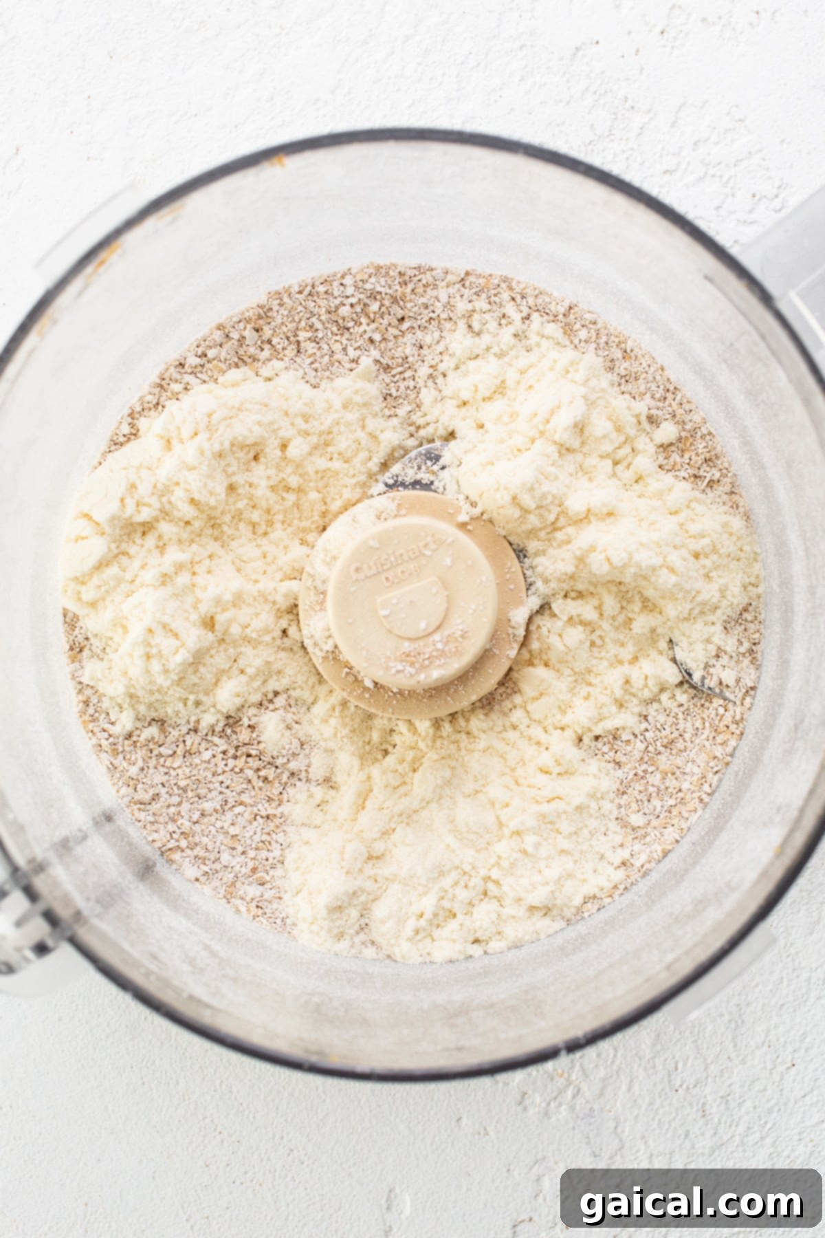 Healthy Protein Cookie Dough Bites 4 A food processor filled with blended oat flour and other dry ingredients, ready for wet ingredients to be added.