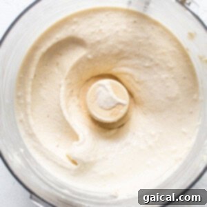 Sunshine Lemon Cheesecake Nice Cream 10 A food processor blending the nice cream mixture, showing a creamy white substance.