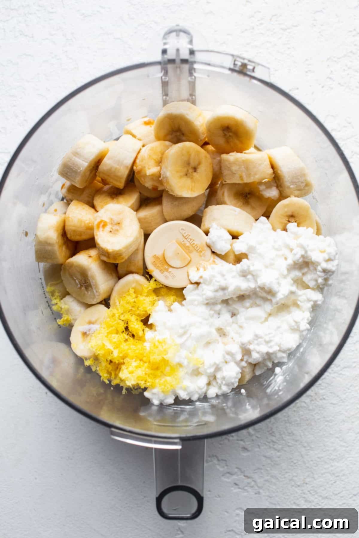Sunshine Lemon Cheesecake Nice Cream 4 A bowl filled with the base ingredients for Lemon Cheesecake Nice Cream: sliced frozen bananas and creamy cottage cheese.