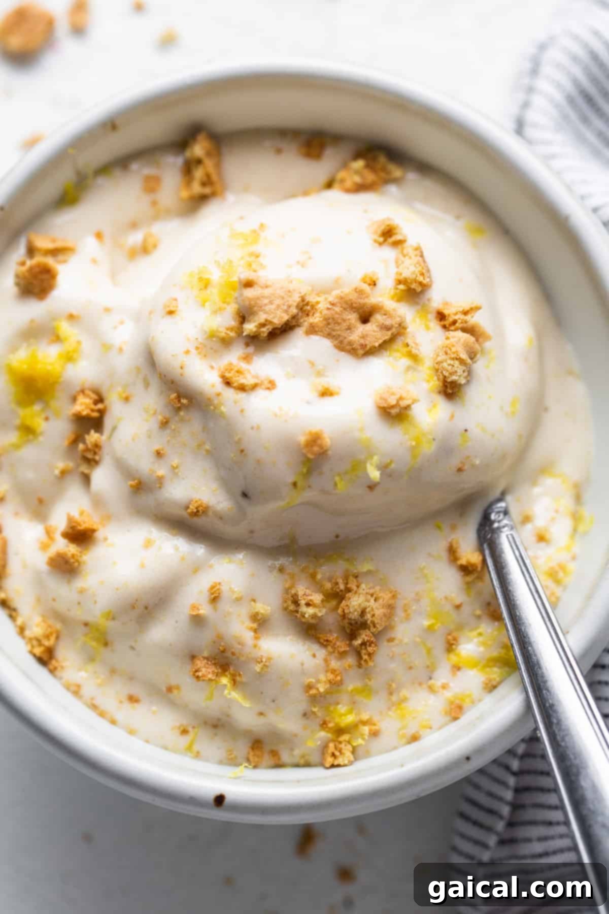 Sunshine Lemon Cheesecake Nice Cream 6 A delightful bowl of Lemon Cheesecake Nice Cream with a spoon, ready to be enjoyed.