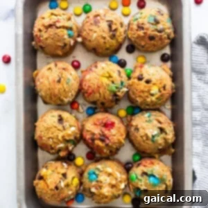 A baking sheet filled with cookies and m&m's.
