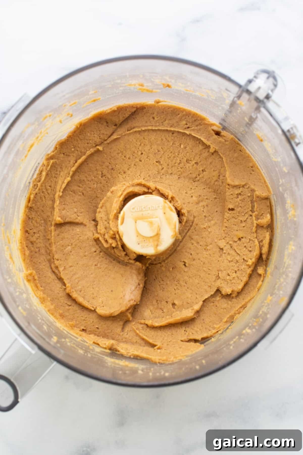 Epic Protein Cookie Dough 4 Close-up of smooth peanut butter being blended in a food processor, showing the creamy texture.