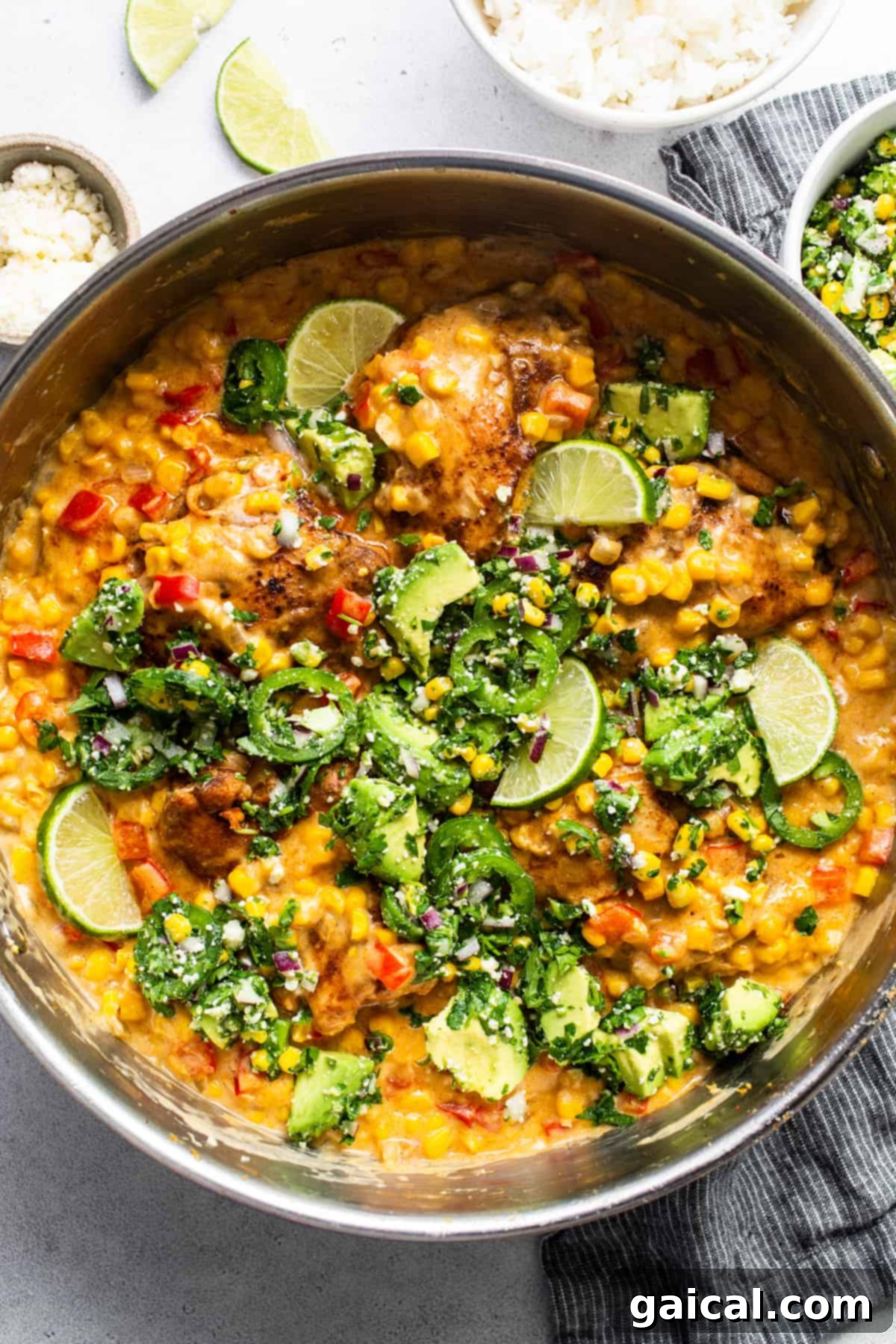 A vibrant bowl of creamy street corn chicken with vegetables and a fresh slaw topping, ready to be served.