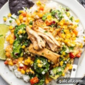 A white plate featuring creamy street corn chicken with fresh toppings.